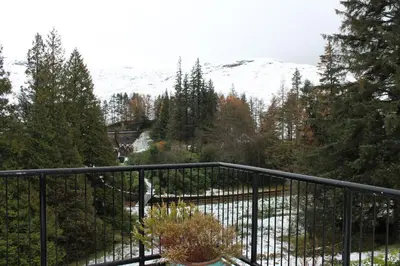 a balcony with a view of a snow covered mountain at Loch Arklet House in Stirling