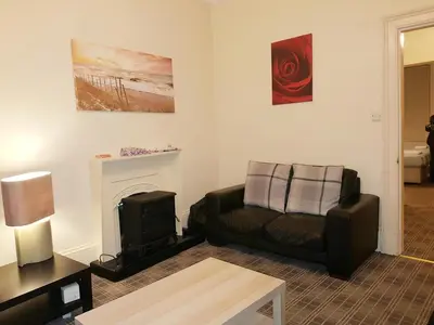 a living room with a couch and a fireplace at Glen View Apartments in Port Glasgow