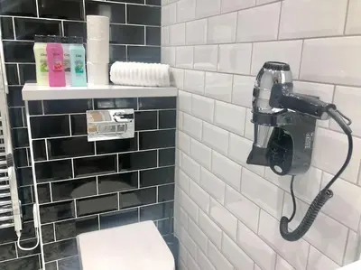 a bathroom with a hair dryer and a phone on the wall at Central, Bright 2 Bed Flat - Pool & Sauna in Edinburgh