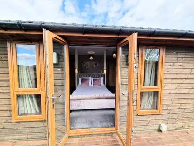 an open door of a tiny house with a bed at Torridon 1 with Private Hot Tub - Fife - Loch Leven - Lomond Hills- Pet Friendly in Kelty