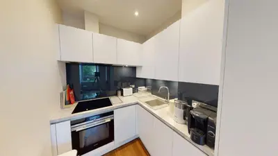 a white kitchen with white cabinets and a sink at The Westfield in Edinburgh
