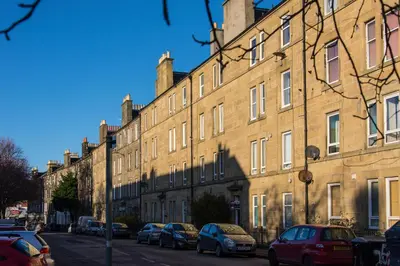 a large brick building with cars parked on a street at The Westfield in Edinburgh