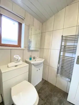 a white bathroom with a toilet and a sink at Ochil 10 with Private Hot Tub - Fife - Loch Leven - Lomond Hills in Kelty