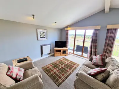 a living room with two couches and a television at Ochil 10 with Private Hot Tub - Fife - Loch Leven - Lomond Hills in Kelty