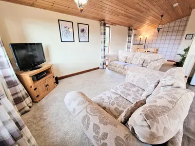 a living room with two couches and a flat screen tv at Lomond 6 with Private Hot Tub - Fife - Loch Leven - Lomond Hills in Kelty
