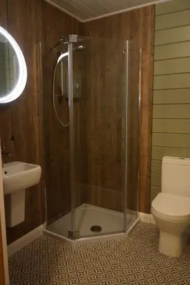 a bathroom with a shower with a toilet and a sink at Cosy & compact Rowan Lodge no4 in Killin