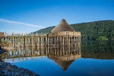 a bridge over a lake with its reflection in the water at Cosy & compact Rowan Lodge no4 in Killin