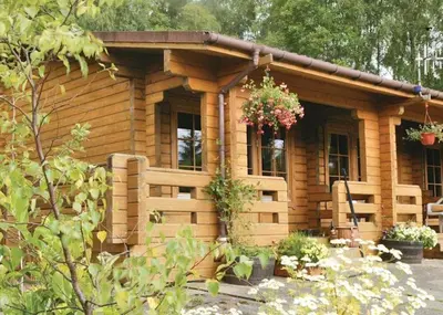 a log cabin with a flower hanging from it at Cosy & compact Rowan Lodge no2 in Killin