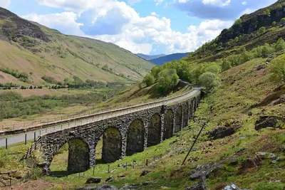 a bridge on a hill with a train on it at Woodland Gean Lodge in Killin