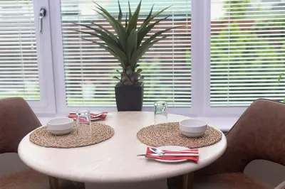 a dining room table with two chairs and a plant at Glenview Luss in Luss