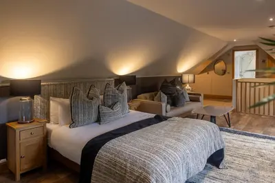 a bedroom with a large bed and a living room at Glenview Luss in Luss