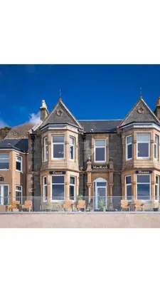 a large brick building with benches in front of it at MacKays in Oban