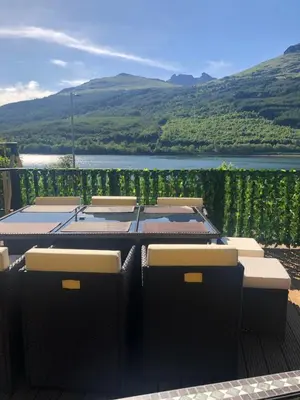 a group of tables with a view of a lake at Amazing Alps and Loch views - HOT TUB and pet friendly in Arrochar