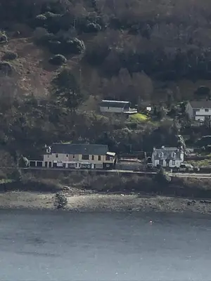 a group of houses on a hill next to the water at Amazing Alps and Loch views - HOT TUB and pet friendly in Arrochar