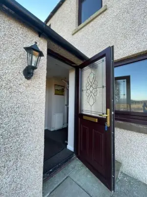 a door to a building with a window and a lamp at Carminnows Holiday Cottage in Carsphairn