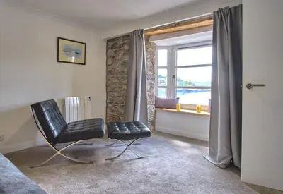 a black chair in a room with a window at Imperial Apartment in Oban