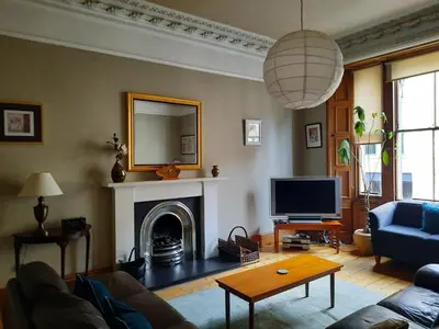 a living room with a couch and a tv at Cornwall Street - 297 in Edinburgh
