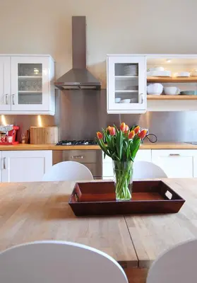 a kitchen with a table with a vase of flowers on it at Saxe Coburg Place - 325 in Edinburgh