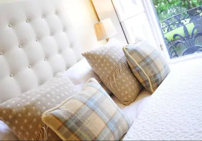 a bedroom with a bed with pillows and a window at Saxe Coburg Place - 325 in Edinburgh