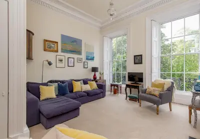 a living room with a purple couch and chairs at Saxe Coburg Place - 325 in Edinburgh