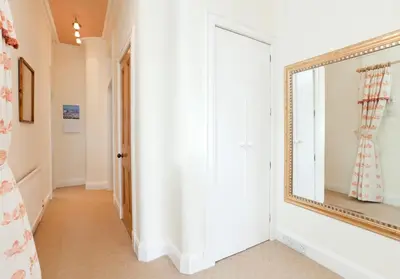 a hallway with a mirror and a door at Mardale Crescent - 380 in Edinburgh