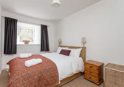 a bedroom with a white bed and a window at Dean Path - 400 in Edinburgh