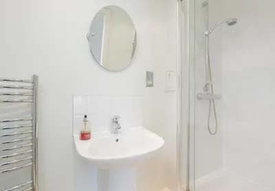 a white bathroom with a sink and a shower at Thistle Street - 401 in Edinburgh