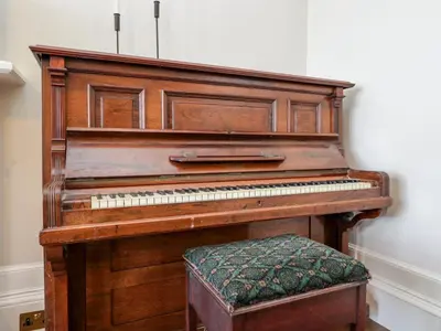 a wooden piano sitting in a room at East Firwood in Rothesay