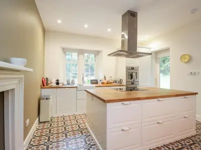a kitchen with white cabinets and a counter top at East Firwood in Rothesay