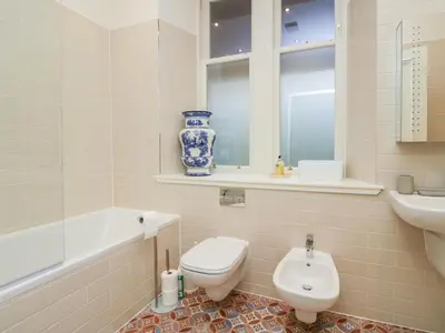 a bathroom with a toilet and a sink and a tub at East Firwood in Rothesay