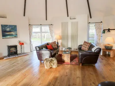a living room with two chairs and a dog in it at The Roundhouse in Auchterarder