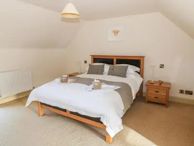 a bedroom with a large bed with white sheets at The Roundhouse in Auchterarder
