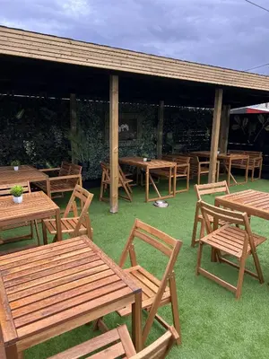 a group of wooden tables and chairs on the grass at Glendevon Hotel in Auchterarder