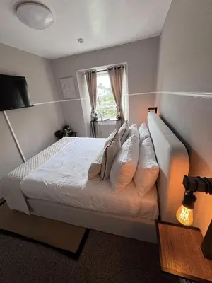 a bedroom with a bed with pillows and a window at Glendevon Hotel in Auchterarder