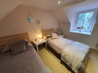 a bedroom with two beds and a window at Cromla Cottage in Corrie