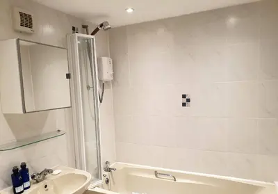 a bathroom with a shower and a sink and a tub at Cromla Cottage in Corrie