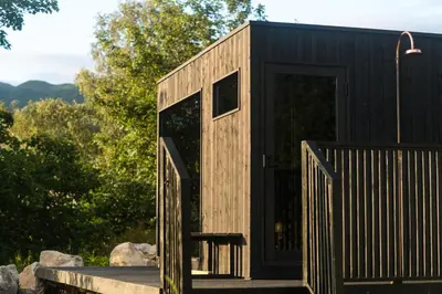 a black tiny house with a black door at SeaBeds - Luxury Lookouts with Hot Tubs in Glencoe