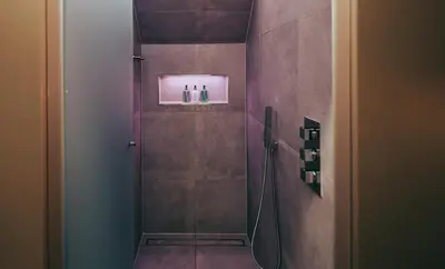 a bathroom with a shower with two bottles on a shelf at SeaBeds - Luxury Lookouts with Hot Tubs in Glencoe