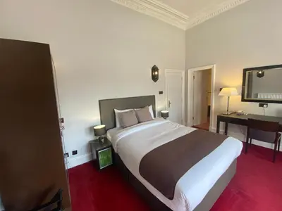 a hotel room with a large bed and a desk at No6 West Coates in Edinburgh
