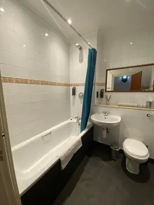 a bathroom with a tub and a toilet and a sink at No6 West Coates in Edinburgh
