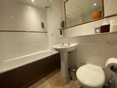 a bathroom with a sink and a toilet and a tub at No6 West Coates in Edinburgh