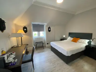 a bedroom with a bed and a desk and a table with a chair at No6 West Coates in Edinburgh