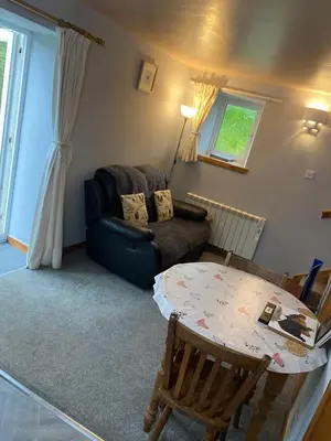 a living room with a table and a couch at Barfad Self Catering Holiday Cottages in Tarbert