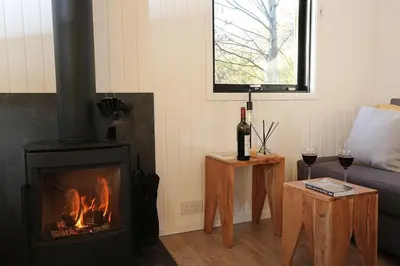 a living room with a fireplace and a couch at Cosy Modern Nordic Lodge w/ Loch View & Log Burner in Lochearnhead