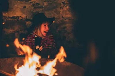 a woman sitting in front of a fire at Boreland Loch Tay in Aberfeldy