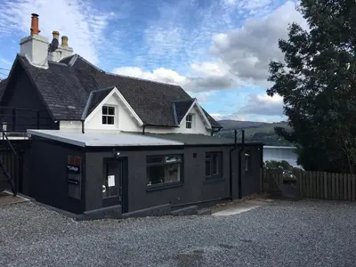 a black and white house with a building at Boreland Loch Tay in Aberfeldy