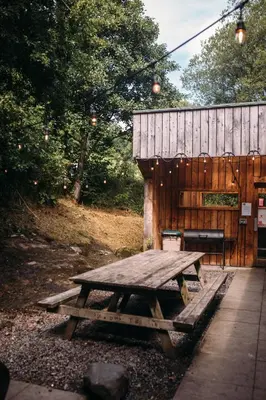a picnic table in front of a wooden building at Boreland Loch Tay in Aberfeldy