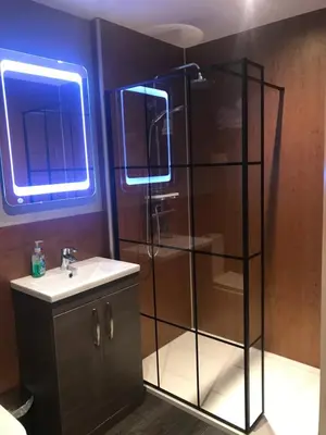 a bathroom with a shower with a sink and a mirror at The Shack & Pods at Inchree in Corran