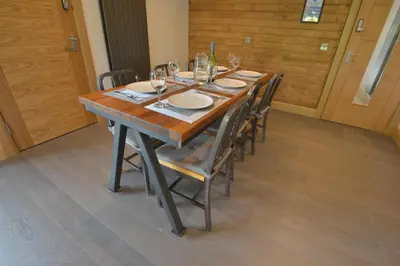 a long wooden table with chairs and wine glasses at The Shack & Pods at Inchree in Corran