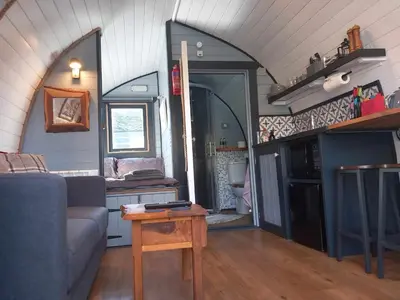 a living room with a couch and a table at Etive Pod, West Highland Way Holidays in Kinlochleven